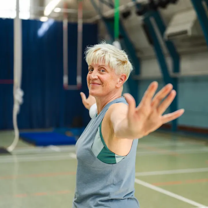 Smiling older woman exercising in a gym