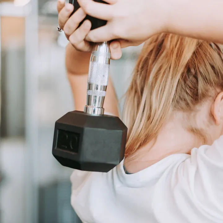 Woman strength training with a dumbbell